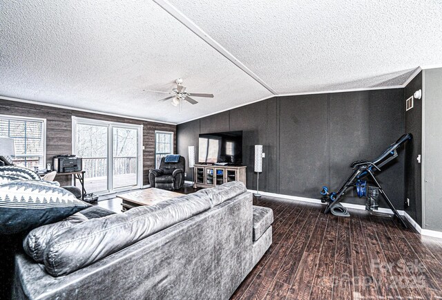 living area featuring wood finished floors, a textured ceiling, baseboards, ceiling fan, and lofted ceiling