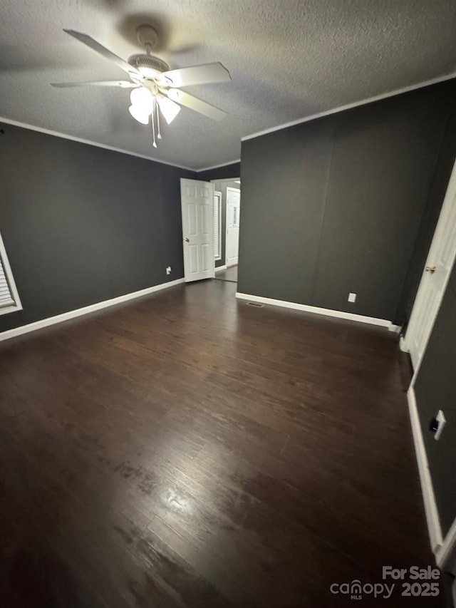 unfurnished bedroom featuring dark wood finished floors, baseboards, a textured ceiling, and ceiling fan