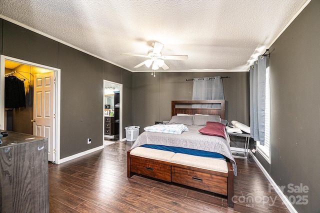 bedroom featuring ornamental molding, a textured ceiling, wood finished floors, baseboards, and a ceiling fan