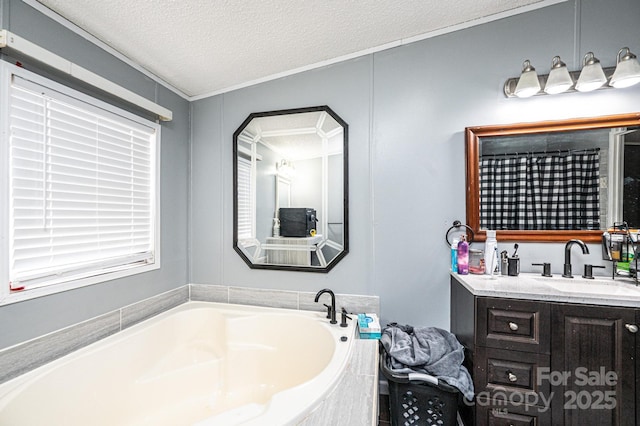 full bath with a textured ceiling, a garden tub, ornamental molding, and vanity