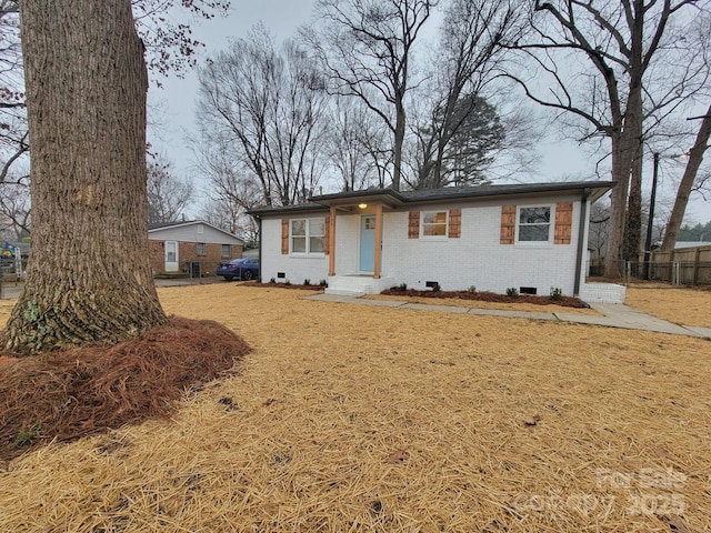 ranch-style house with crawl space, brick siding, fence, and a front lawn