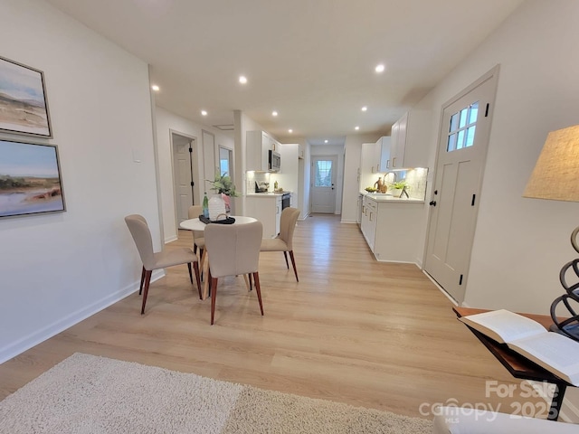 dining area with recessed lighting, light wood finished floors, and baseboards