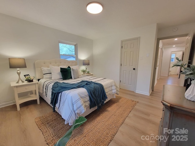 bedroom featuring baseboards and light wood finished floors