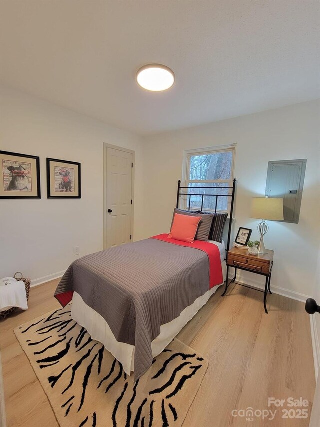 bedroom with light wood-type flooring and baseboards
