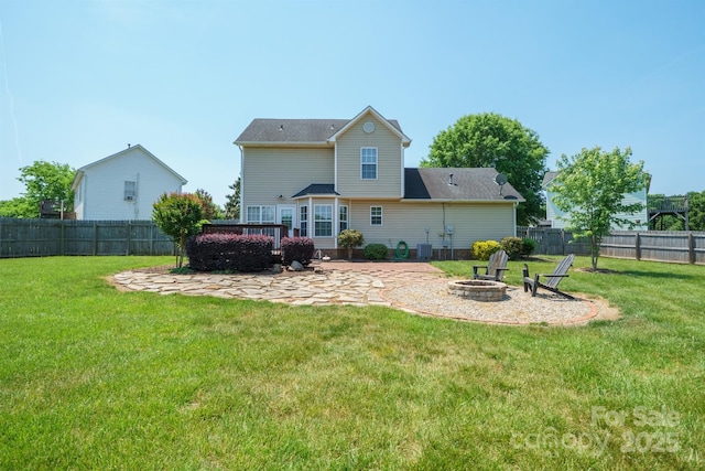 rear view of house with a fenced backyard, a patio area, a yard, and an outdoor fire pit