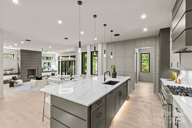 624 Heather Ln, Charlotte, NC 28209 - kitchen featuring a sink, high end range, premium range hood, a large island with sink, and recessed lighting