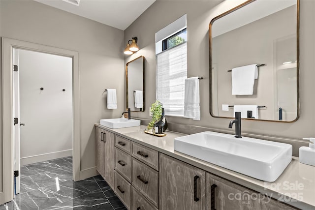 624 Heather Ln, Charlotte, NC 28209 - bathroom featuring marble finish floors, double vanity, and baseboards