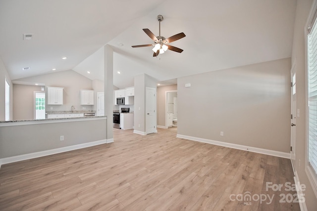 unfurnished living room featuring visible vents, a sink, light wood-style floors, high vaulted ceiling, and a ceiling fan