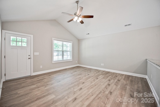 foyer with a ceiling fan, baseboards, wood finished floors, lofted ceiling, and visible vents