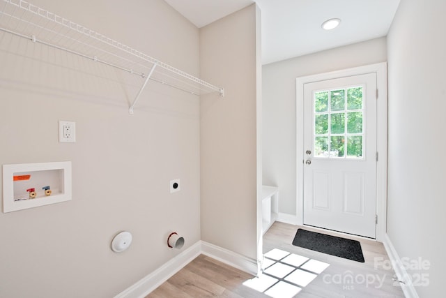 clothes washing area featuring laundry area, baseboards, electric dryer hookup, light wood-style flooring, and washer hookup