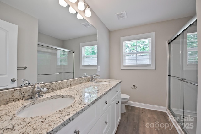 full bathroom featuring an enclosed shower, toilet, visible vents, and a sink