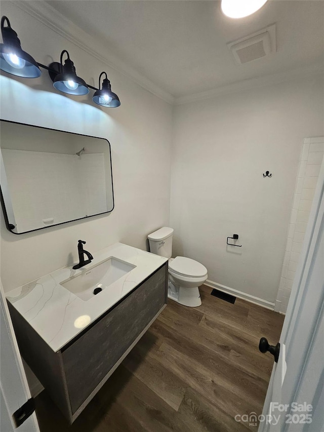 1109 Reid Harkey Rd, Matthews, NC 28105 - bathroom with ornamental molding, wood finished floors, toilet, vanity, and baseboards