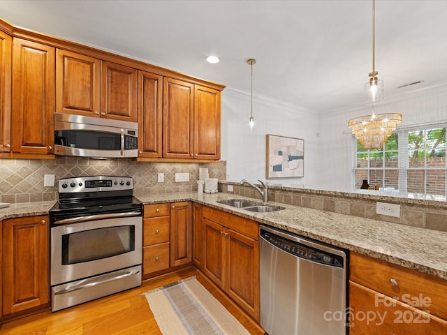 140 Villa Lake Dr, Fort Mill, SC 29708 - kitchen with appliances with stainless steel finishes, a sink, light wood-style floors, brown cabinets, and crown molding