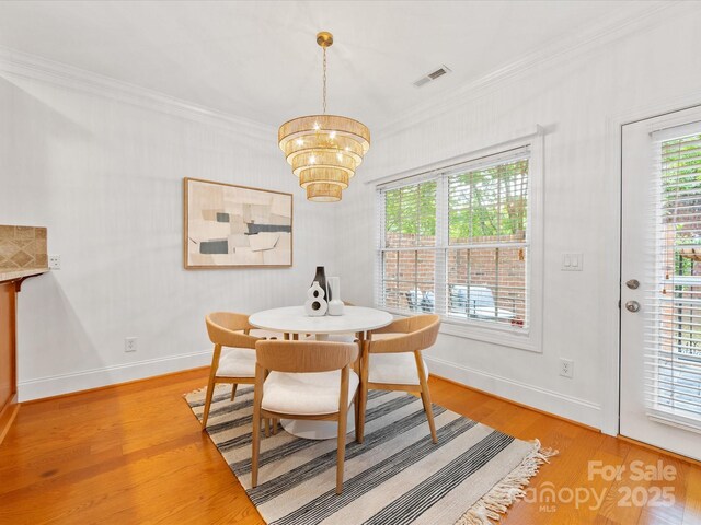 140 Villa Lake Dr, Fort Mill, SC 29708 - dining room featuring a chandelier, crown molding, light wood-style floors, healthy amount of natural light, and baseboards