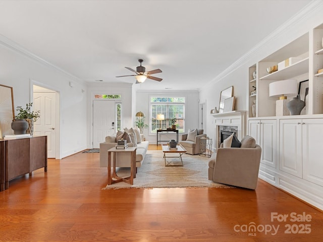 140 Villa Lake Dr, Fort Mill, SC 29708 - living room with a ceiling fan, wood finished floors, a fireplace, ornamental molding, and built in shelves