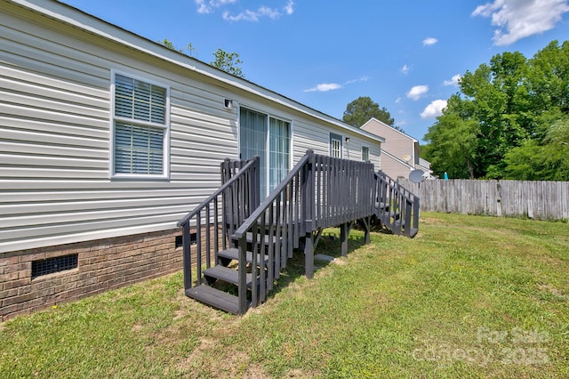 entrance to property with a yard, crawl space, fence, and a deck