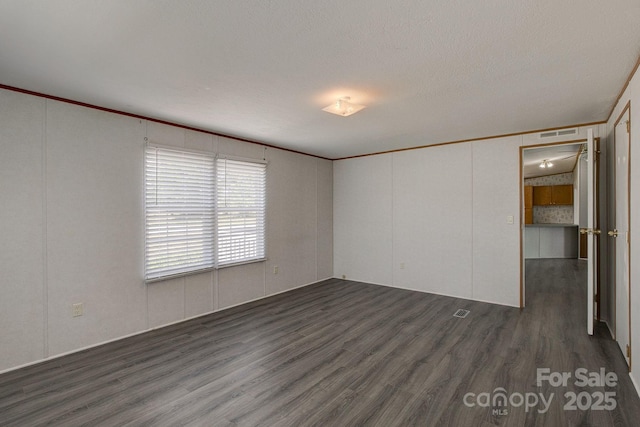 unfurnished room featuring crown molding and dark wood-style flooring