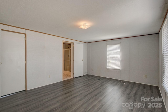 unfurnished bedroom with ornamental molding and wood finished floors