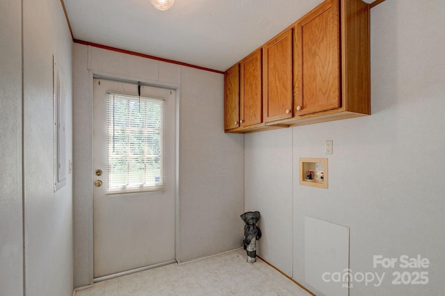 laundry room featuring cabinet space, hookup for a washing machine, baseboards, light floors, and ornamental molding