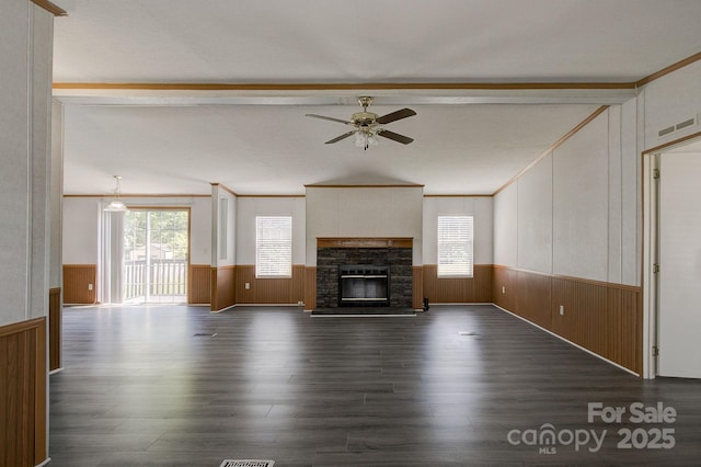 unfurnished living room featuring visible vents, a wainscoted wall, a healthy amount of sunlight, and vaulted ceiling with beams