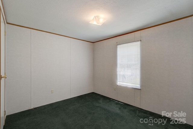 unfurnished room with ornamental molding, dark colored carpet, and a textured ceiling