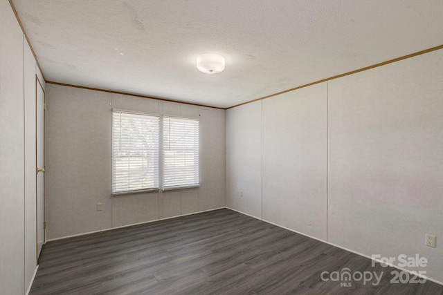 unfurnished room featuring crown molding, a textured ceiling, and wood finished floors