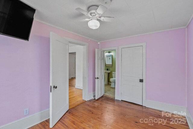 unfurnished bedroom with light wood-type flooring, baseboards, ornamental molding, and ceiling fan