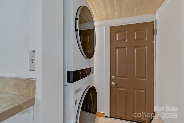 laundry room featuring stacked washer / drying machine and wood ceiling