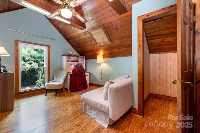 living area featuring a ceiling fan, vaulted ceiling with beams, wood ceiling, and wood finished floors
