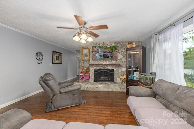 804 Rostan St SE, Valdese, NC 28690 - living room featuring crown molding, ceiling fan, wood finished floors, a stone fireplace, and baseboards