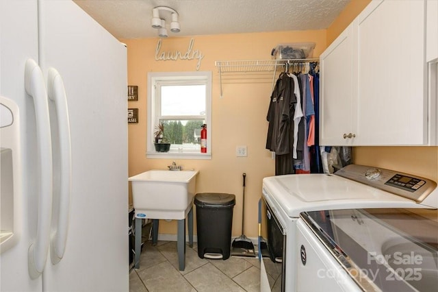 804 Rostan St SE, Valdese, NC 28690 - laundry area with washing machine and dryer, cabinet space, and light tile patterned flooring