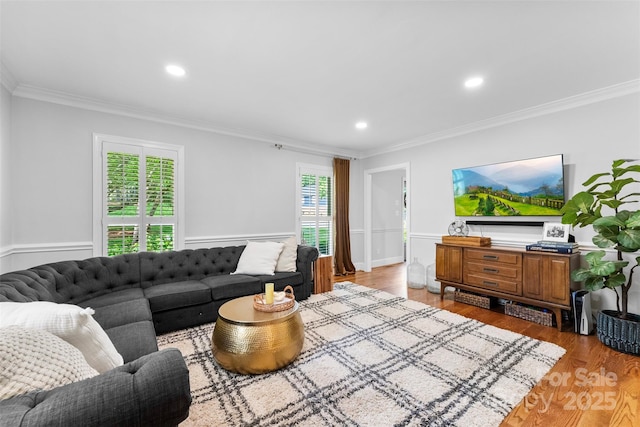 living room featuring light wood-style floors, ornamental molding, and recessed lighting