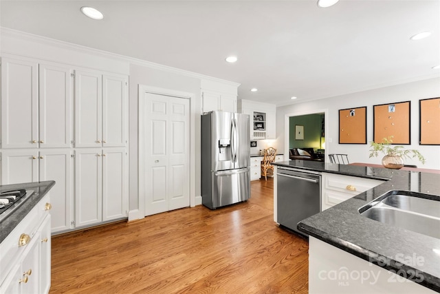 kitchen featuring crown molding, white cabinets, stainless steel appliances, recessed lighting, and light wood-style flooring