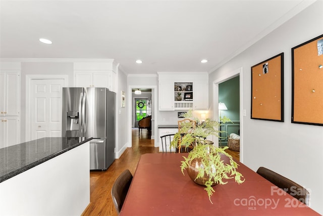 dining space with ornamental molding, recessed lighting, and wood finished floors