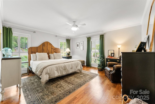 bedroom featuring crown molding, wood finished floors, and multiple windows