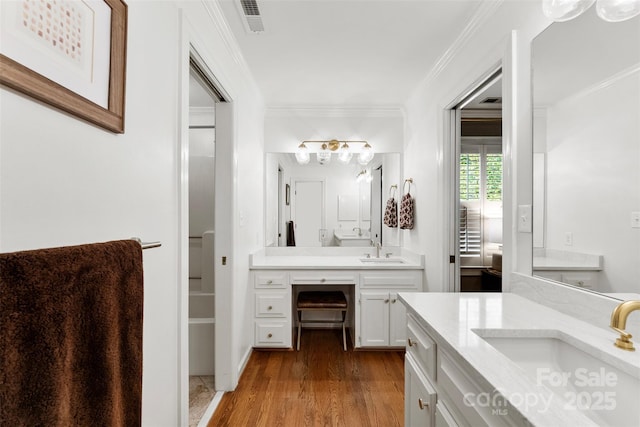 bathroom featuring a sink, crown molding, and visible vents