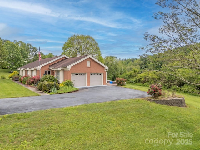 view of side of property featuring a garage, driveway, and a lawn