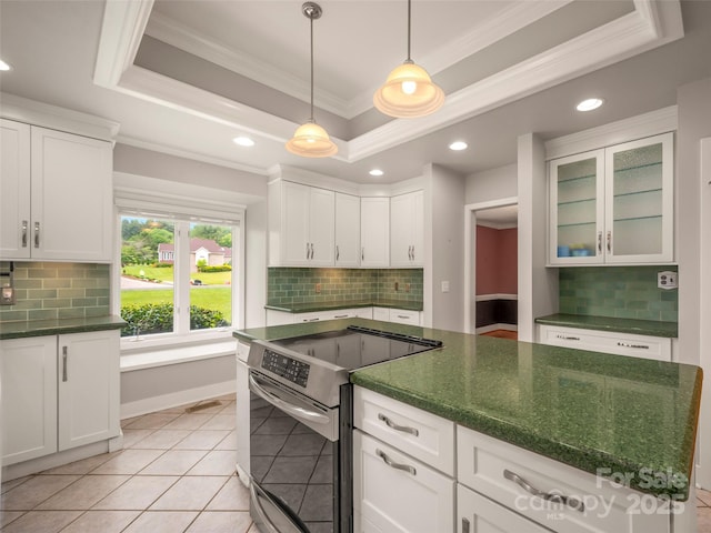 kitchen featuring stainless steel range with electric stovetop, a raised ceiling, ornamental molding, decorative backsplash, and white cabinets