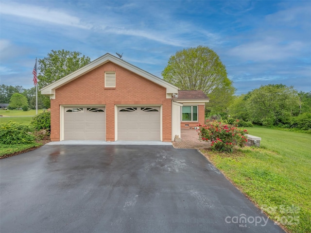 ranch-style home featuring brick siding, asphalt driveway, a front lawn, and a garage