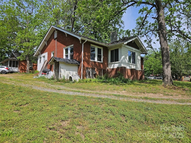 621 Benton St, Monroe, NC 28110 - view of property exterior with a yard, brick siding, and a chimney
