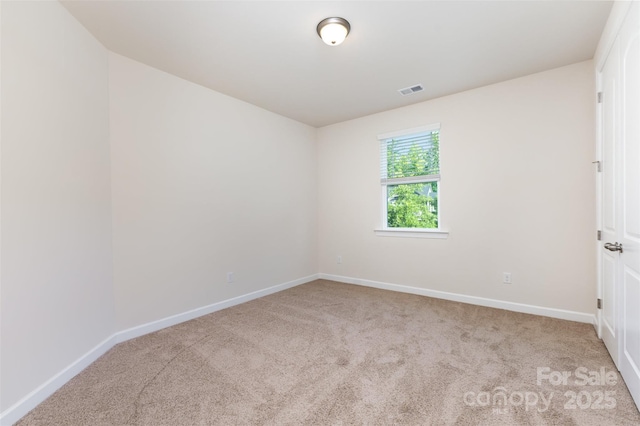 spare room featuring carpet floors and baseboards