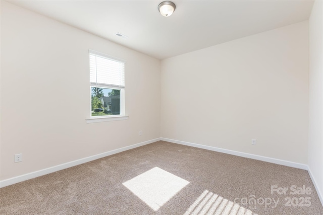 spare room with carpet and baseboards