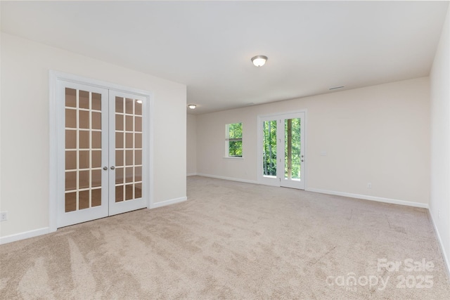 empty room with french doors, carpet flooring, and baseboards