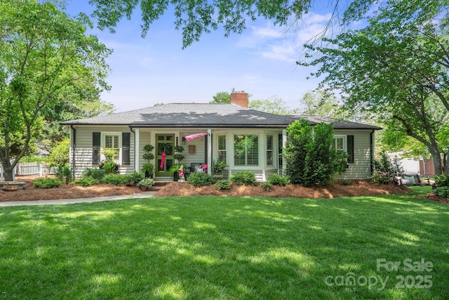 ranch-style house featuring a front lawn, roof with shingles, and a chimney