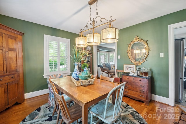 dining area with light wood finished floors and baseboards