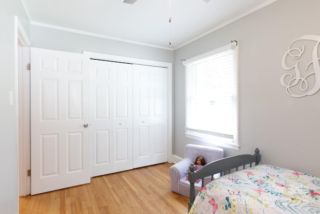 bedroom featuring a closet, ornamental molding, and light wood-type flooring