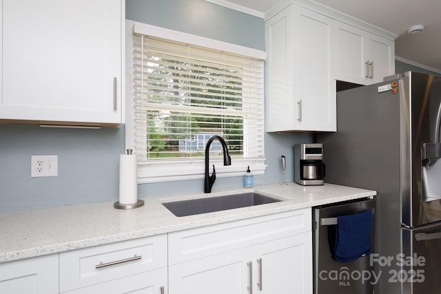 kitchen with a sink, white cabinets, and stainless steel appliances