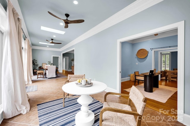 living area with visible vents, ornamental molding, ceiling fan, tile patterned floors, and a skylight