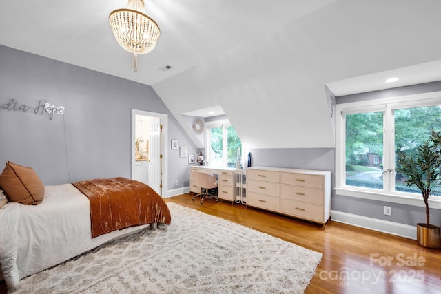 bedroom featuring baseboards, vaulted ceiling, light wood-style flooring, and an inviting chandelier