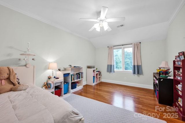 bedroom with ornamental molding, vaulted ceiling, wood finished floors, and visible vents